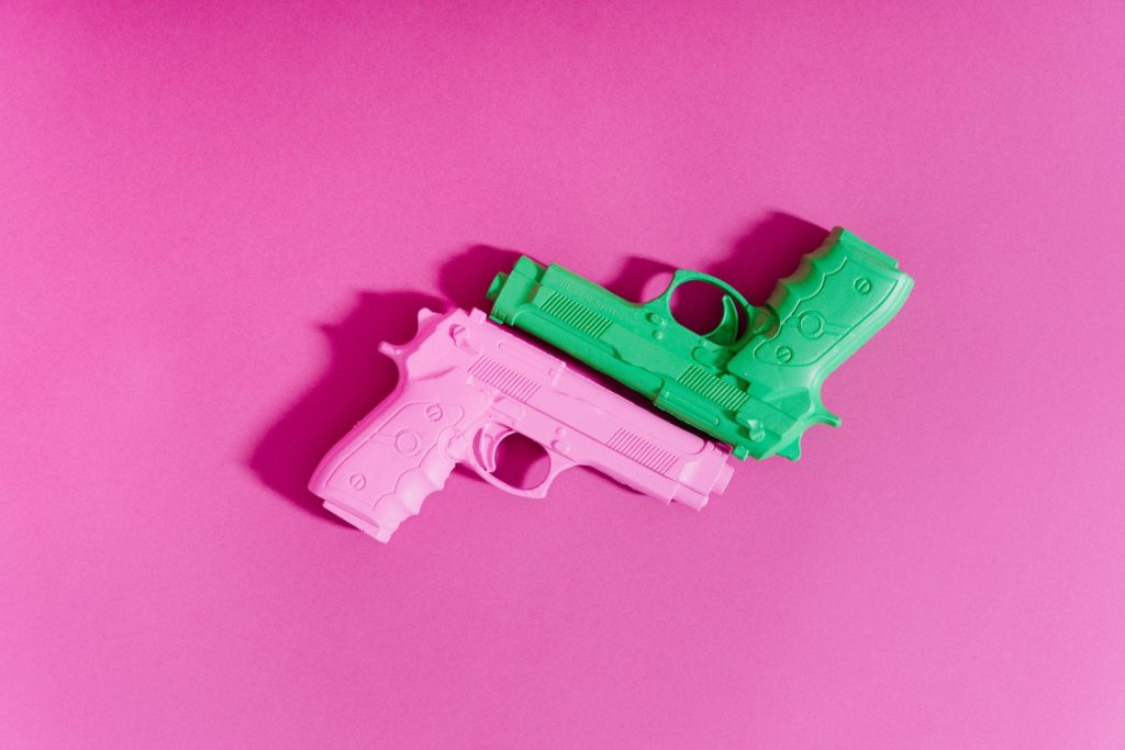 toy guns on pink surface