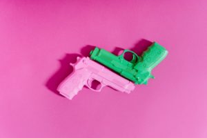 toy guns on pink surface