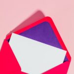 open envelope on pink studio background